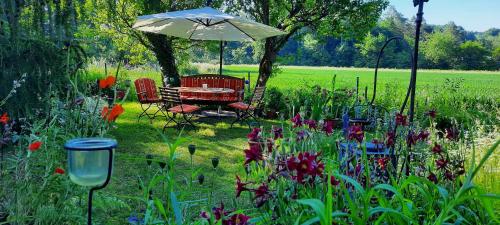 - une table et des chaises sous un parasol dans le jardin dans l'établissement Ferienwohnung Vogelnest, à Betzenstein