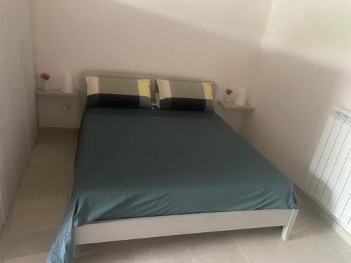 Una cama con dos almohadas encima en una habitación. en casa diamantik 2, en Martina Franca