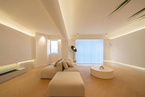 a living room with two white couches and a table at Pure Home-Near the Bund enjoys the beautiful scenery of the Bund 3-bedhome close to Yuyuan Garden Huaihai Road and Nanjing Road Pedestrian Street in Shanghai