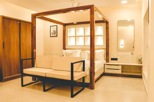 a room with a bed and a chair and a mirror at Mythwish Resort and Farms 