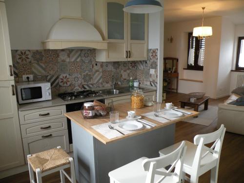 a kitchen with a counter with chairs and a table at Il Nido nel Borgo in Valfabbrica