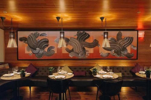 a dining room with tables and a painting on the wall at The Ritz-Carlton, Toronto in Toronto