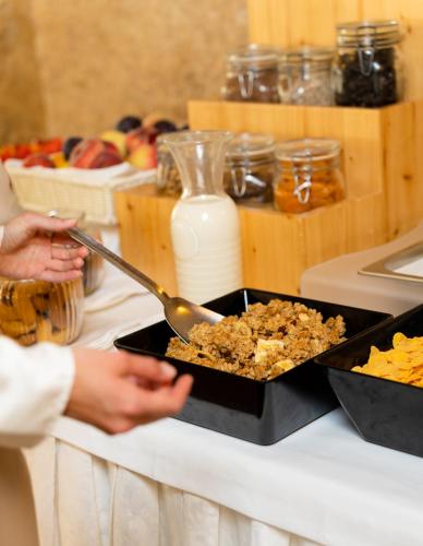 a person holding a pan of food on a counter at Grand Hotel Duca D'Este in Tivoli Terme