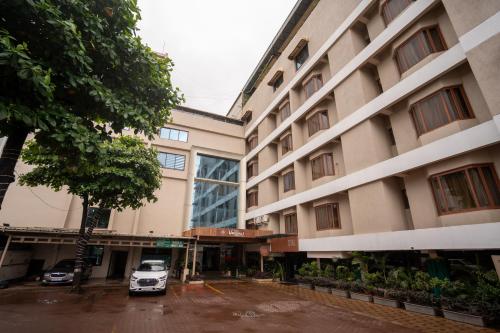 a parking lot in front of a building at Hotel Vrishali Executive in Kolhapur