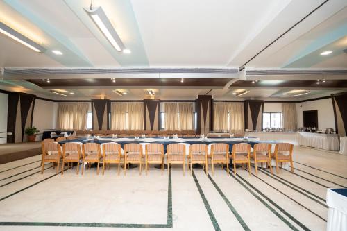a conference room with a long table and chairs at Hotel Vrishali Executive in Kolhapur