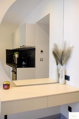 a kitchen with white cabinets and a vase with a plant at YamaLuxe Luxury Apartments - București in Bucharest