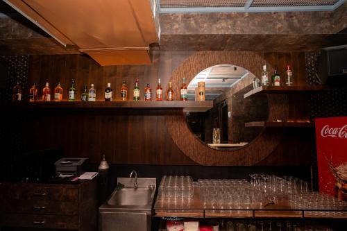 a bar with a lot of bottles and a mirror at Hotel Vrishali Executive in Kolhapur