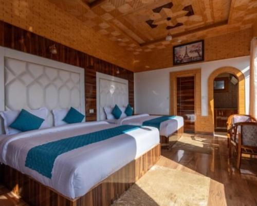 ein Schlafzimmer mit zwei Betten mit blauen Kissen in der Unterkunft The Warmth & Welcome Hotel I Vacations I Conference I MICE I Family Events I Open Air Terrace I Sky Bonfire I Wooden Rooms With Pvt Balconies I Kufri by Exotic Stays in Kūfrī