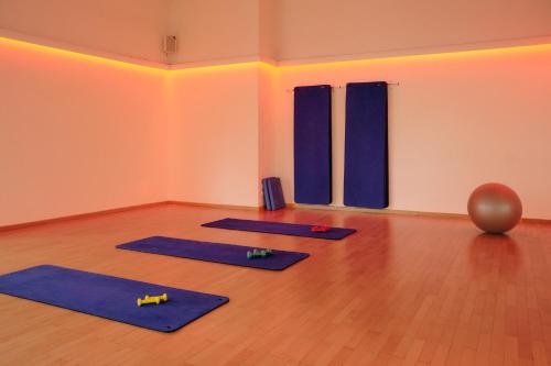 a yoga class with blue mats on a wooden floor at Steigenberger Hotel Treudelberg Hamburg in Hamburg