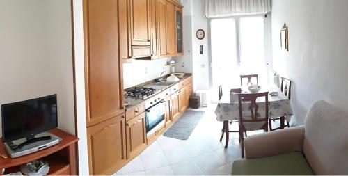 a kitchen with wooden cabinets and a table and a television at Ca da Simo in Albenga