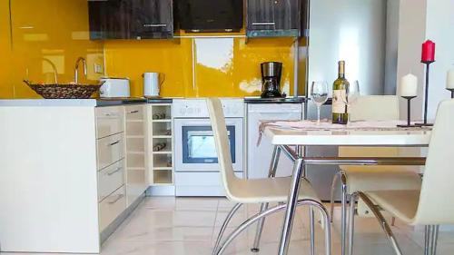 a kitchen with a table and two chairs with wine glasses at Sea La Vie Apt. in Paleokastritsa