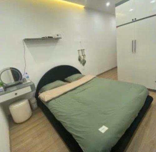a bedroom with a green bed in a room at Emirlan Homestay in Hue