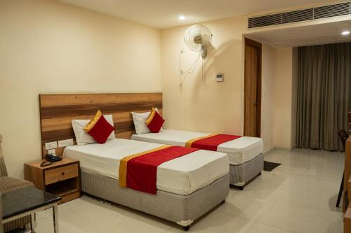 a hotel room with two beds in a room at Hotel Ambicas Grand in Visakhapatnam