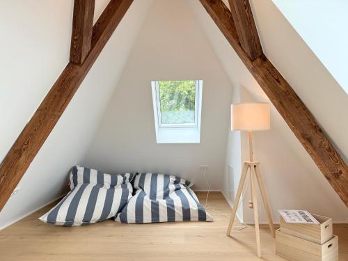 Cette chambre mansardée comprend un lit et une lampe. dans l'établissement Lieblingsplatz, à Überlingen