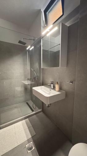 a bathroom with a sink and a shower at Daphne di Palio in Paleo Tsifliki