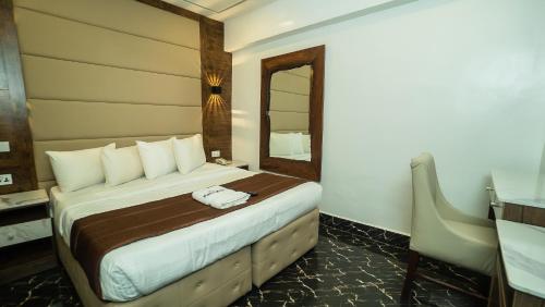 a bedroom with a large bed with a mirror at Presken Hotels, Awolowo Way, Ikeja in Ikeja