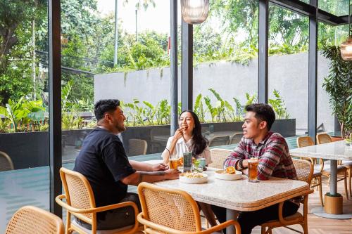 a group of people sitting at a table in a restaurant at ARTOTEL Casa Kuningan in Jakarta