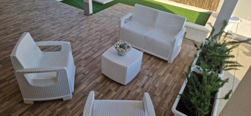 two wicker chairs and a table with a potted plant at Podilimbo - Ilios e Thalassa in Paestum