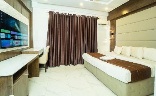 a hotel room with a bed and a desk at Presken Hotels, Awolowo Way, Ikeja in Ikeja
