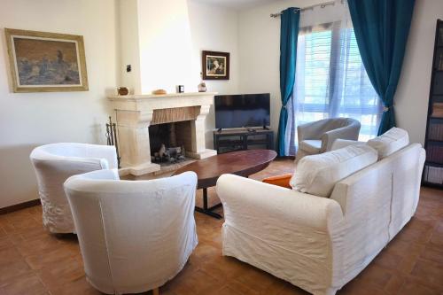 a living room with white furniture and a fireplace at Family house with garden near the sea in Porticcio