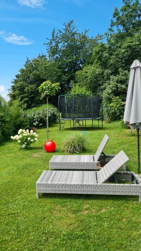 a park bench with a fountain and an umbrella at ZAUBERBERG Apartements in Schwarzendorf
