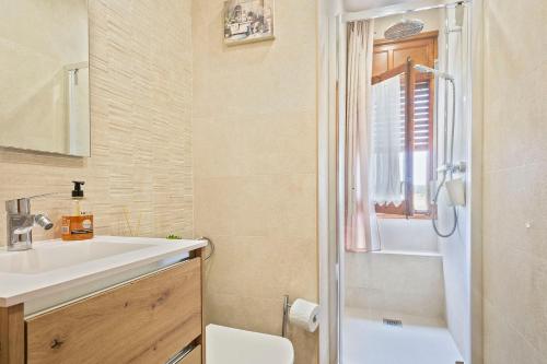 a bathroom with a sink and a toilet and a window at Winahost Calonge Avenida Països Catalans in Calonge