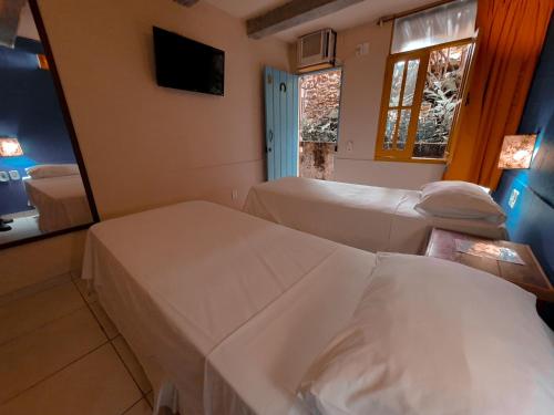 a hospital room with two beds and a mirror at Hotel Estalagem Porto Seguro in Porto Seguro