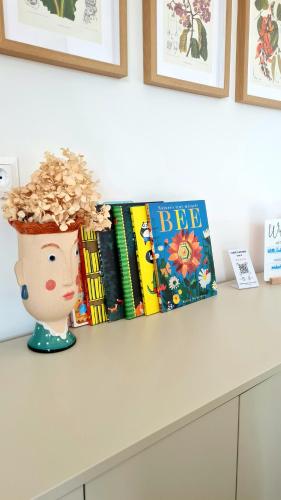 a shelf with books and a vase with a plant at ZAUBERBERG Apartements in Schwarzendorf