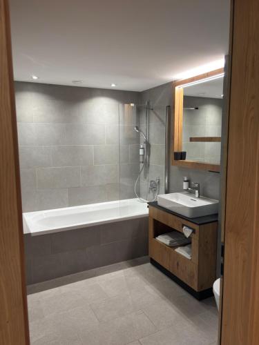 a bathroom with a tub and a sink and a shower at Apart Zwieselblick in Sölden