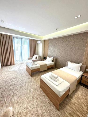 a hotel room with two beds and a couch at North Star Hotel in Yakkasaray