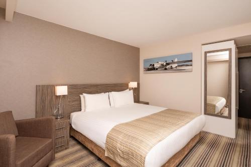a hotel room with a bed and a chair at Holiday Inn Southend by IHG in Southend-on-Sea