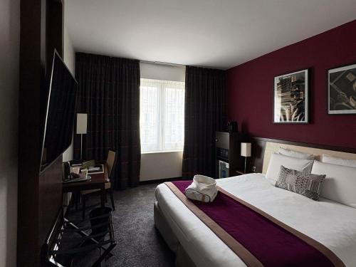 Una habitación de hotel con una cama grande y un escritorio. en Mercure Angers Centre Gare, en Angers