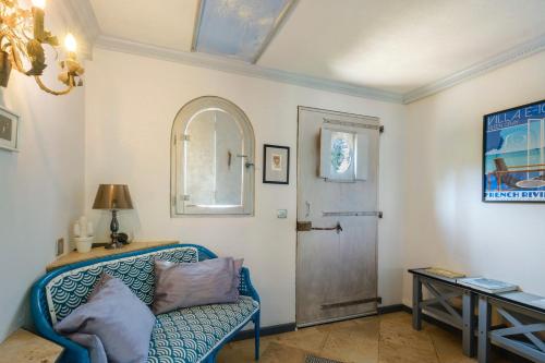 a living room with a blue couch and a door at Sous L'olivier in Menton