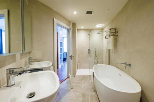 a bathroom with two sinks and a tub and a shower at Mount Wolseley Hotel Spa & Golf Resort in Tullow