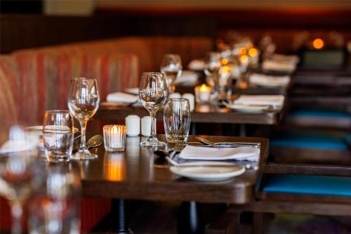 a row of wooden tables with wine glasses and napkins at Mount Wolseley Hotel Spa & Golf Resort in Tullow