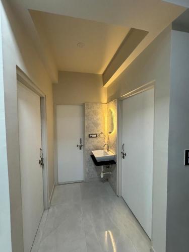 a hallway with a bathroom with a sink and two doors at O2 stay in Jaipur