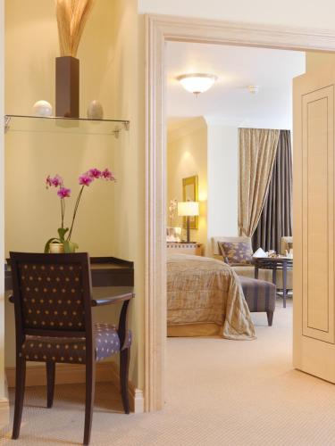 a bedroom with a bed and a desk with flowers on it at Mount Wolseley Hotel Spa & Golf Resort in Tullow
