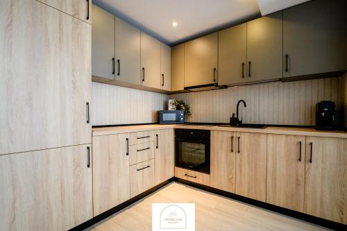 a kitchen with wooden cabinets and a sign on the floor at YamaLuxe Luxury Apartments - București in Bucharest
