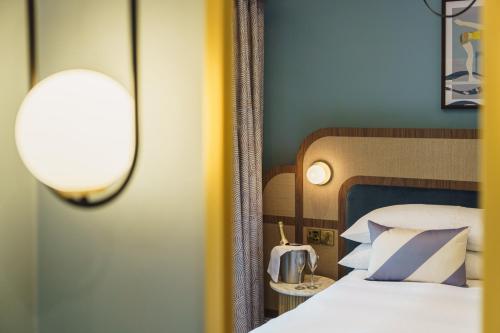 a bedroom with a bed with blue and white pillows at Grange Hotel in Grange Over Sands