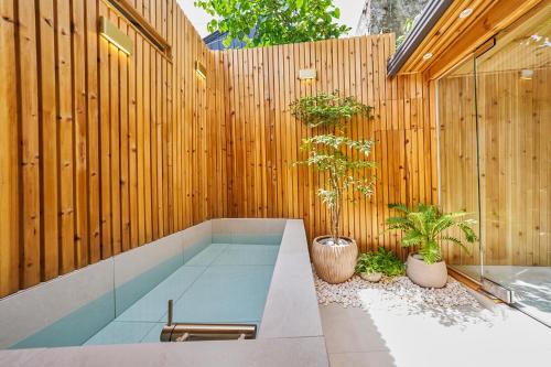 una valla de madera con un banco y dos plantas en Ht Tailored Service Urban Retreat Gym And Garden, en Seúl