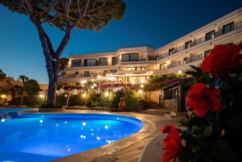 a hotel with a swimming pool in front of a building at Cala del Porto Punta Ala - Preferred Hotels in Punta Ala