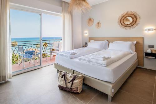 a bedroom with a bed with a view of the ocean at Hotel Moresco in Diano Marina