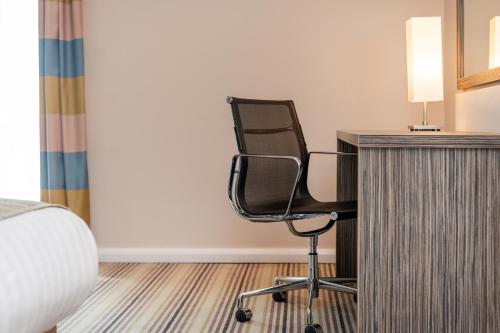 a chair sitting next to a desk in a room at Holiday Inn Southend by IHG in Southend-on-Sea
