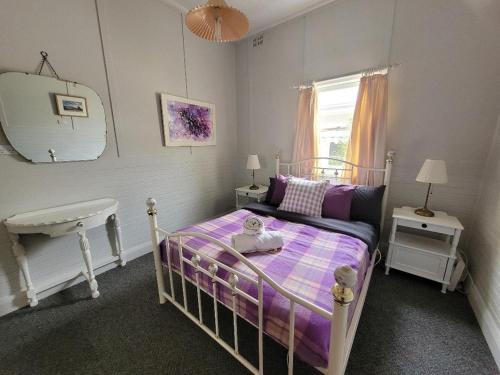 a small bedroom with a bed and a sink at Kandos Cottage in Kandos