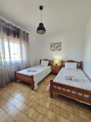 a bedroom with two beds and a window at Costa Mar by Albufeira Rental in Olhos de Água