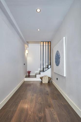 an empty living room with white walls and wood floors at BBarcelona Rogent Flats in Barcelona
