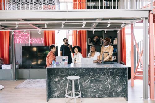 a group of people standing around a counter with laptops at Campus House by Larsen in Tallinn