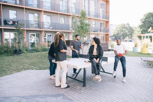 a group of people sitting on a bench in front of a building at Campus House by Larsen in Tallinn