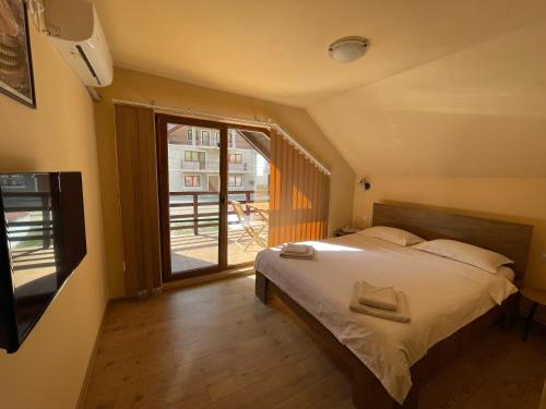 a bedroom with a bed and a large window at Casa Bianca in Băile Herculane