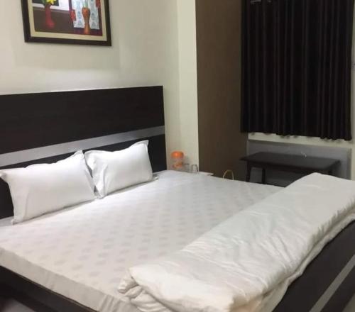 加姆布Hotel AMAR VILAS的卧室里有一张大床，床单和枕头都是白色的